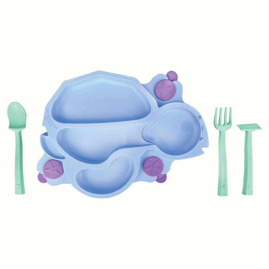 Image of the blue Turtle Training Plate and Utensils. The seafoam green utensils include a pusher, fork and spoon, and are located next to the plate.