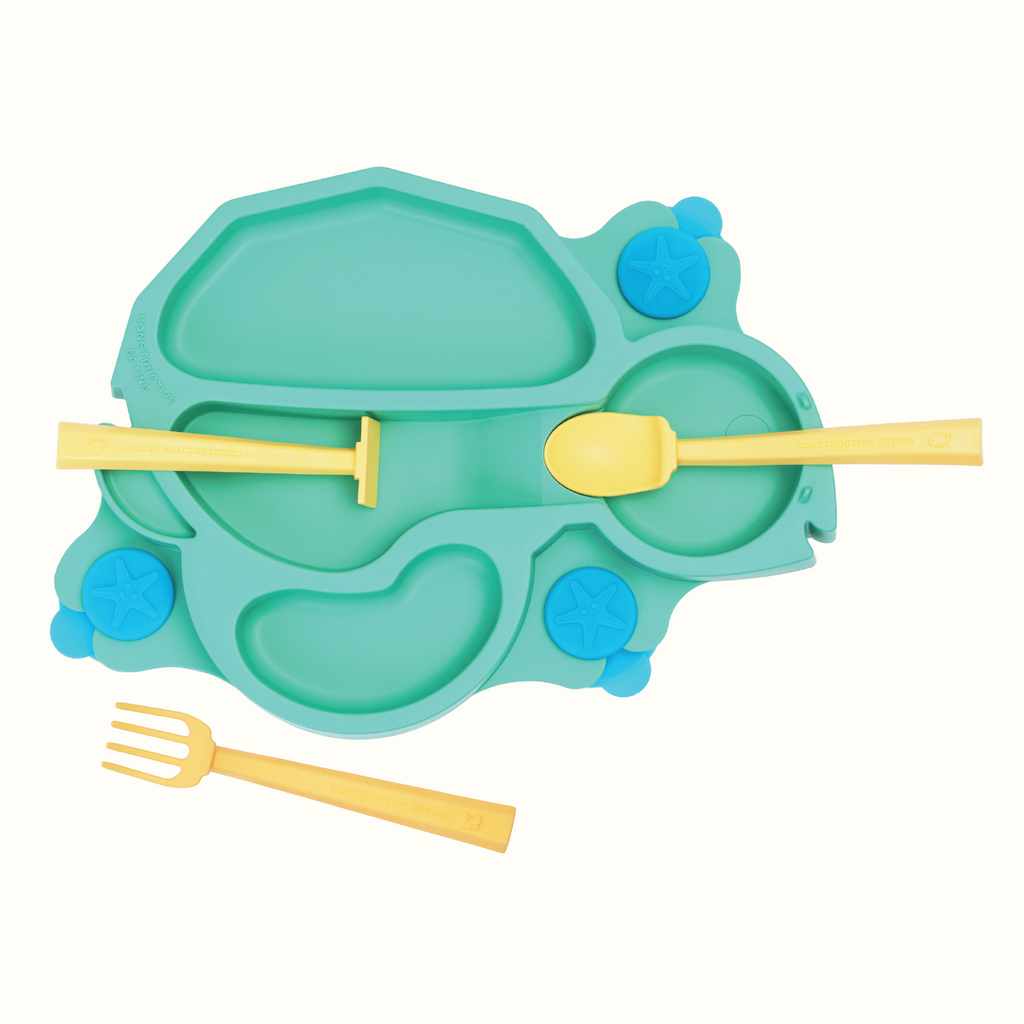 Image of the green Turtle Training Plate and Utensils. The utensils are yellow. The pusher and spoon are located on their designated spots on the plate and the fork is in front of the plate.