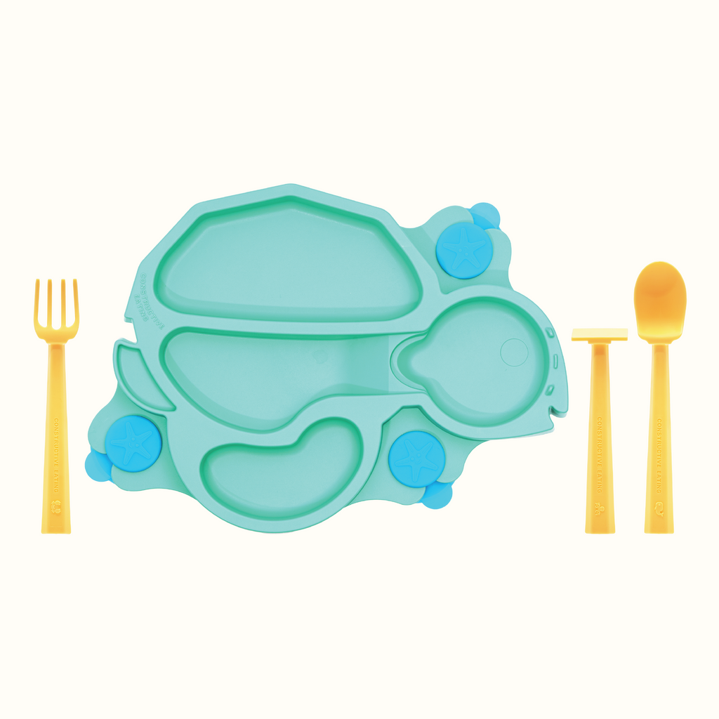 Image of the green Turtle Training Plate and Utensils. The yellow utensils include a pusher, fork and spoon, and are located next to the plate.