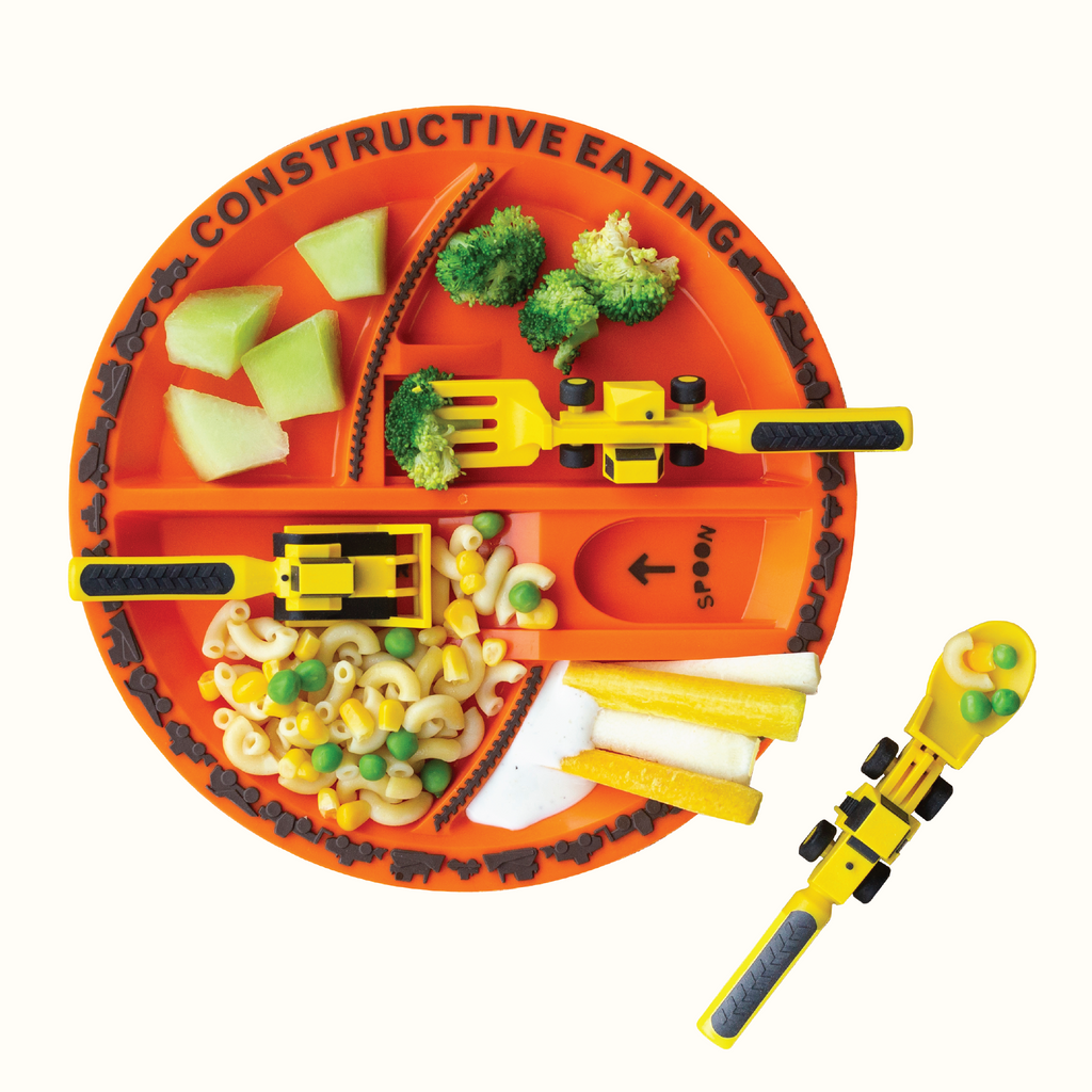 Image of the Construction Utensils and Plate styled with food. The yellow utensils include a bull dozer pusher, a fork lift fork, and a front loader spoon. The plate is orange and is plated with honeydew, broccoli, carrots and ranch, and a simple pasta with macaroni noodles, peas, and corn.